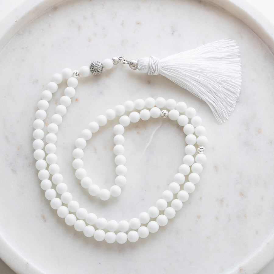 Tasbih (misbaha) i hvid kvarts med 99 naturlige perler, skilleperler i sølv og en hvid kvast på hvid marmor